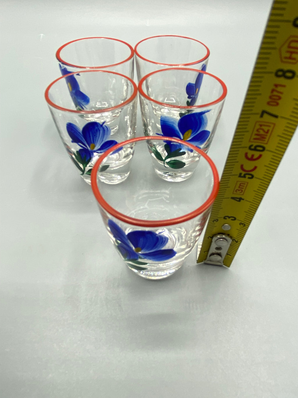 Vue rapprochée des fleurs bleues à cœur jaune et feuillage vert sur les cinq verres