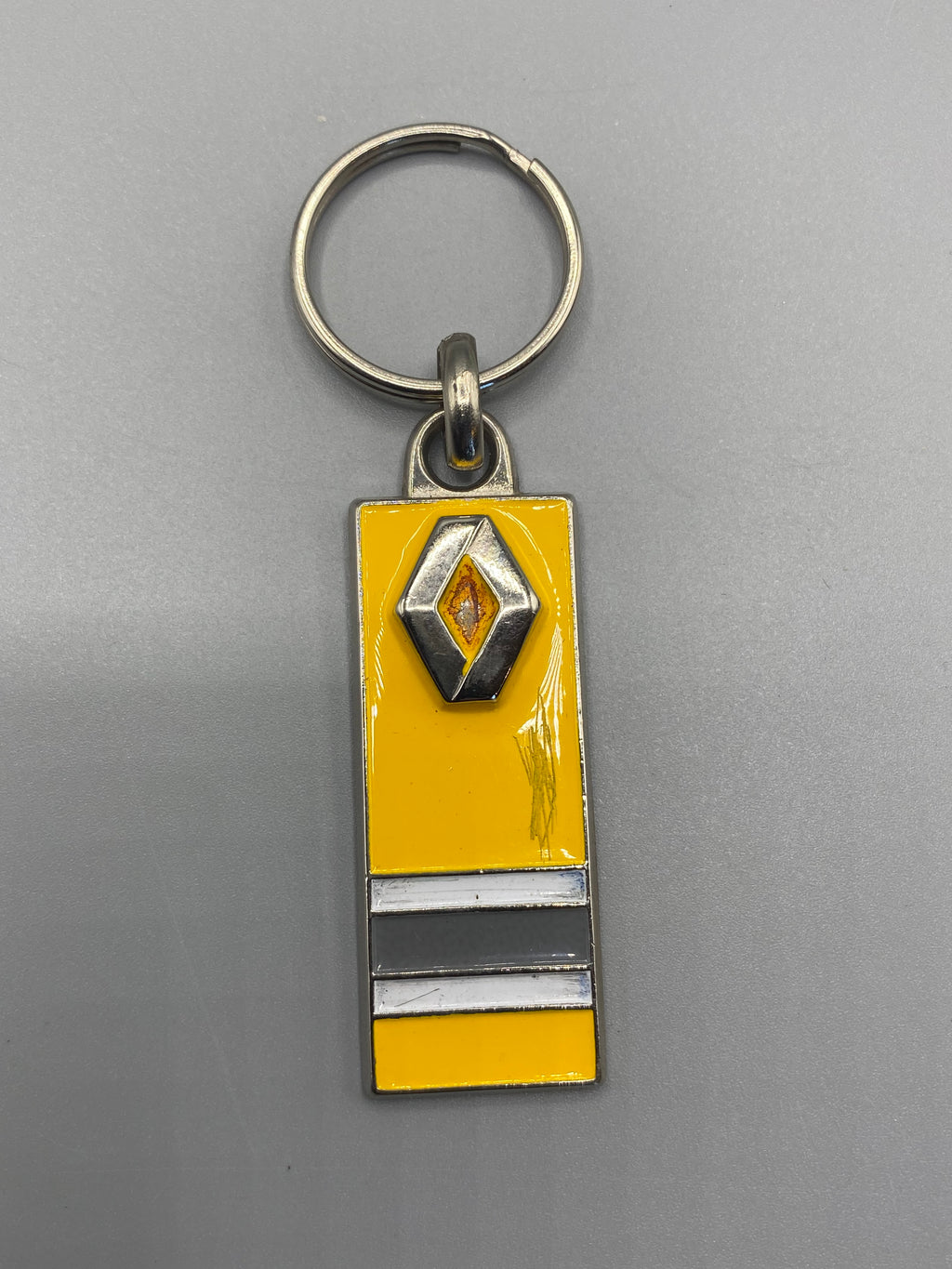 Porte-clés Renault vintage jaune et noir avec losange métallique en relief