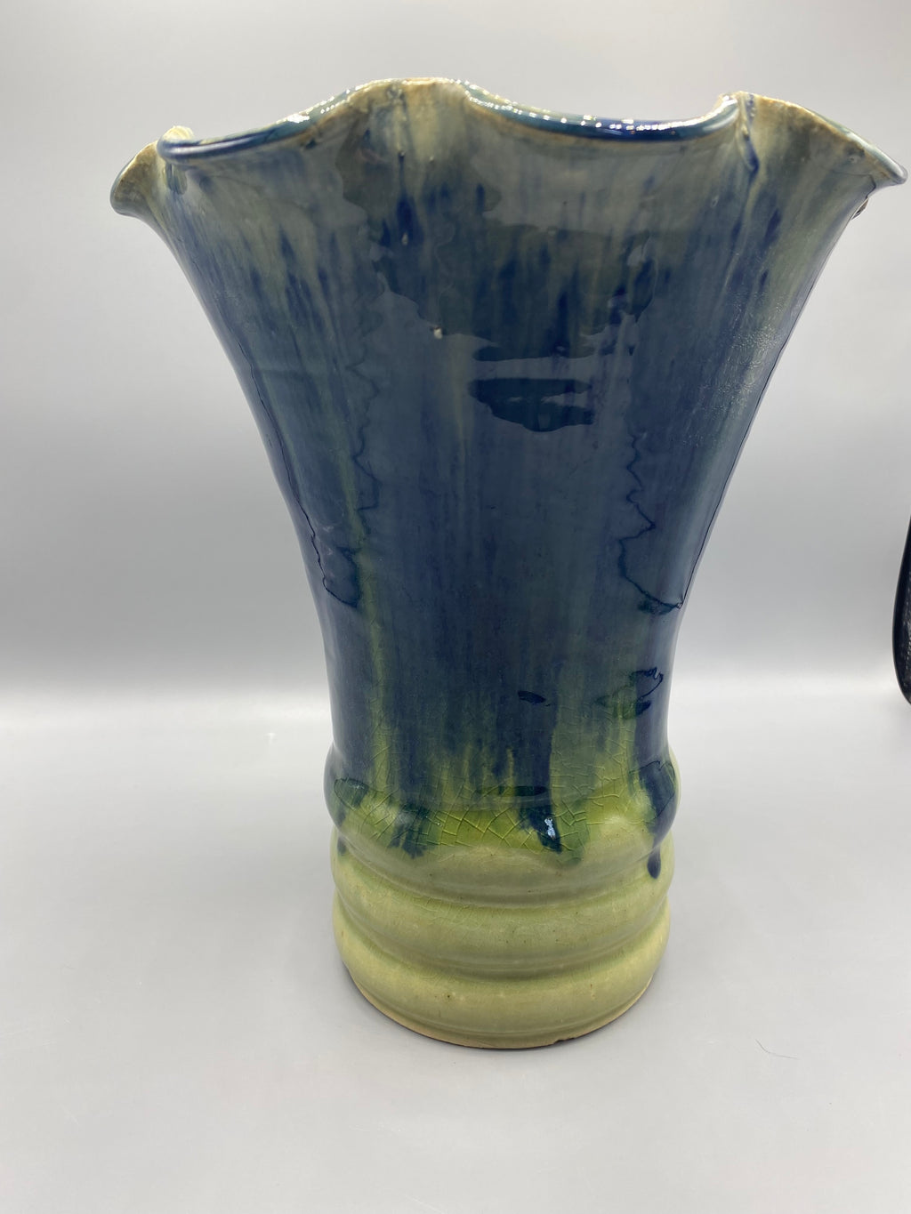 Vue de la silhouette évasée et des coulures bleues du vase
