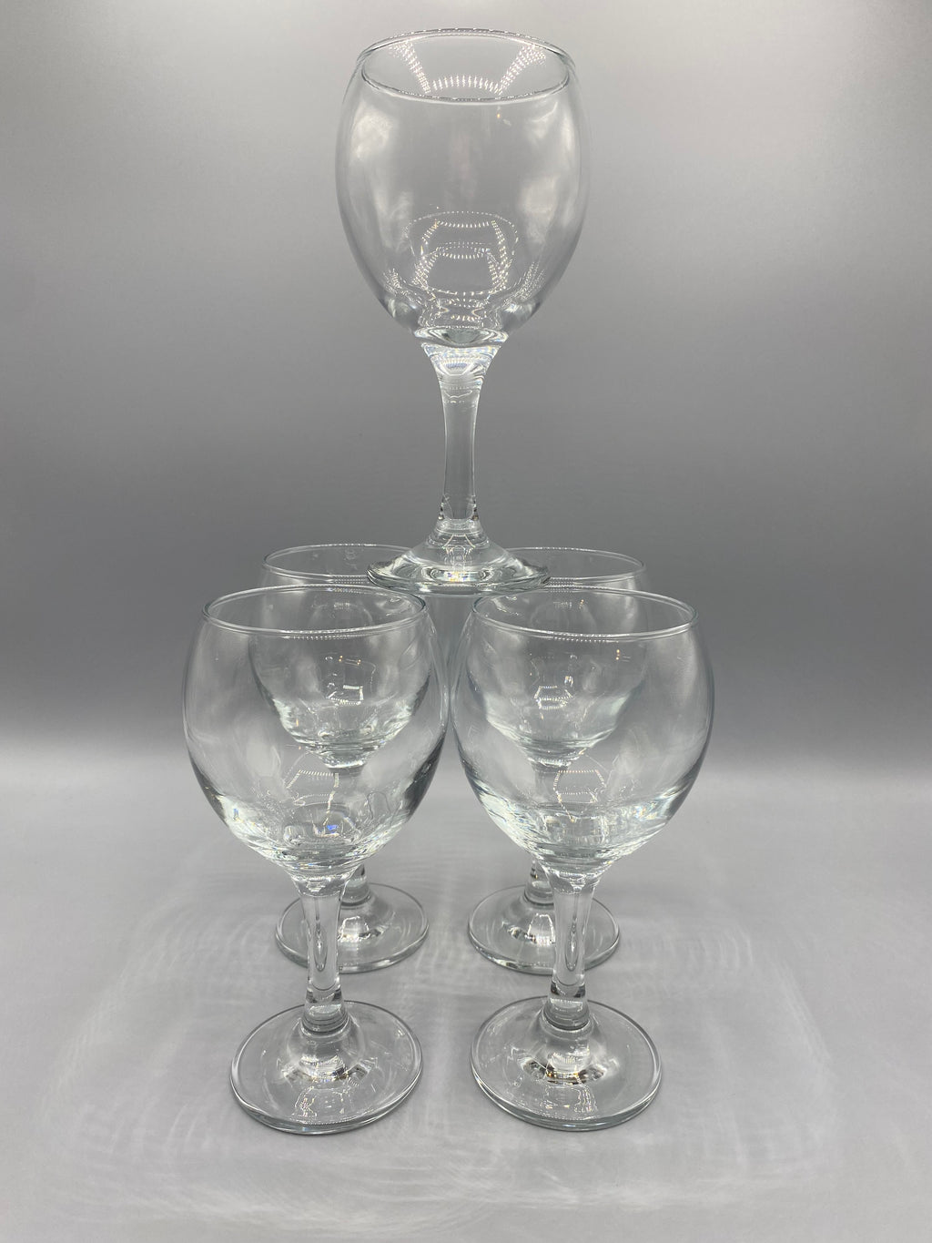 Vue des calices arrondis et des pieds des cinq verres à vin