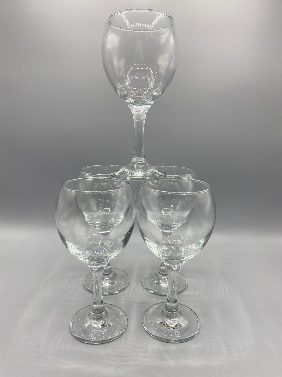 Vue des calices arrondis et des pieds des cinq verres à vin