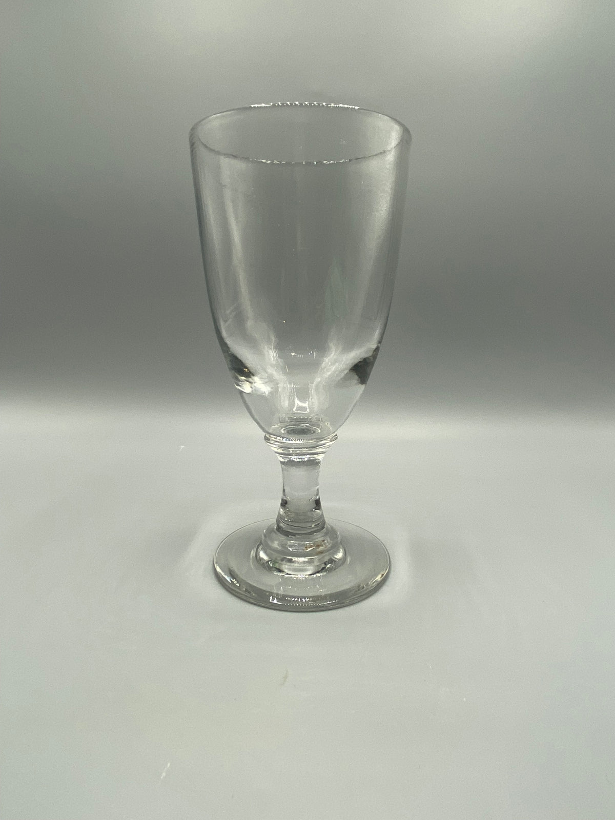 Grand verre à pied ancien transparent, coupe évasée et jambe à balustre